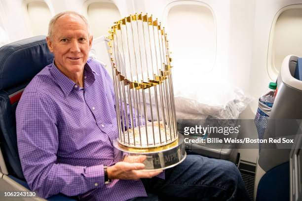 Boston Red Sox bench coach Ron Roenicke holds the World Series trophy as the team travels to Boston after winning the 2018 World Series against the...
