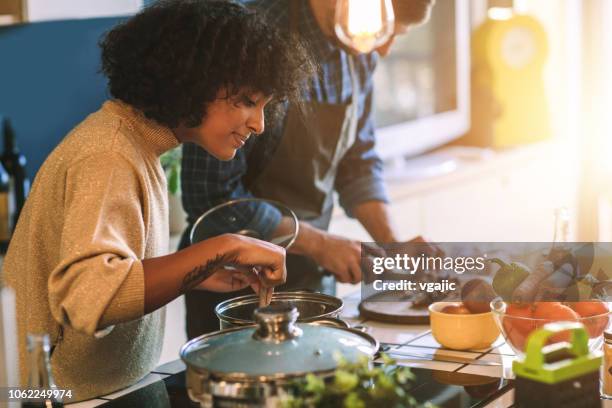 vrienden wonen en samen koken - maaltijd stockfoto's en -beelden