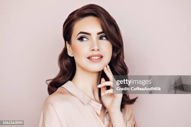 woman with voluminous curly hairstyle - long brown hair stock pictures, royalty-free photos & images