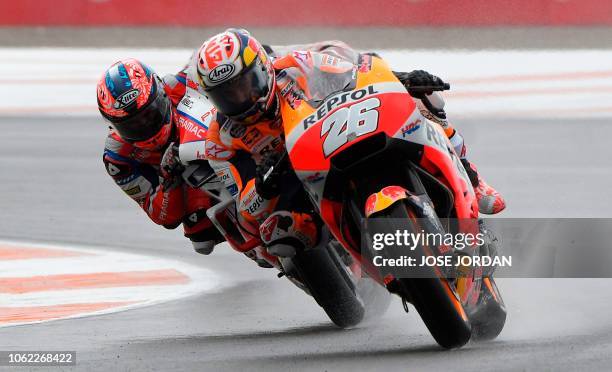 Repsol Honda's Spanish rider Dani Pedrosa and Alma Pramac Racing Italian rider Danilo Petrucci ride during the first free practice session of the...