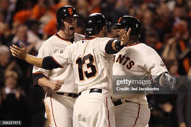 Juan Uribe of the San Francisco Giants celebrates with Cody Ross and Aubrey Huff after hitting a three run homerun in the fifth inning against Darren...