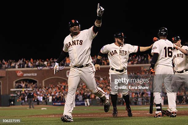 Juan Uribe of the San Francisco Giants celebrates with Cody Ross and Edgar Renteria after hitting a three run homerun in the fifth inning against...