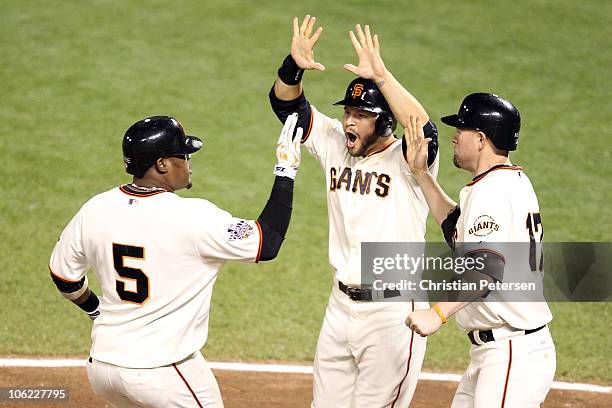 Juan Uribe of the San Francisco Giants celebrates with Cody Ross and Aubrey Huff after hitting a three run homerun in the fifth inning against Darren...