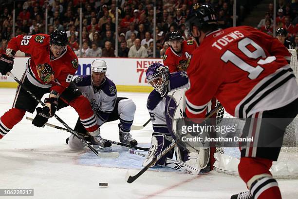 Jonathan Toews of the Chicago Blackhawks fires a shot at Jonathan Bernier and Rob Scuden of the Los Angeles Kings as teammate Tomas Kopecky sets-up...