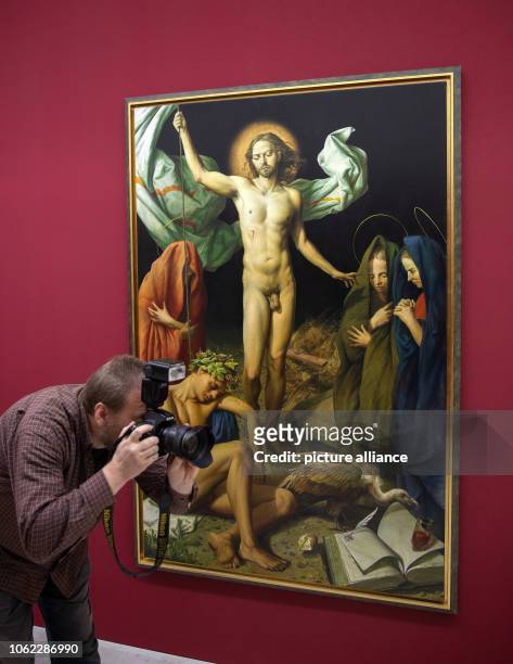 November 2018, Thuringia, Erfurt: A man photographs next to the painting "Resurrection" in the exhibition of the Leipzig painter Michael Triegel in...