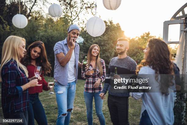 group of people having fun while smoking and drinking at a party - alcohol and smoking stock pictures, royalty-free photos & images