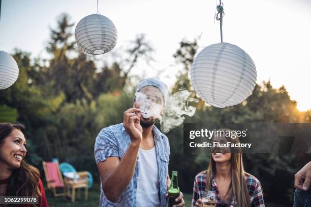 freunde, die rauchen und trinken auf einer party - cigarette stock-fotos und bilder