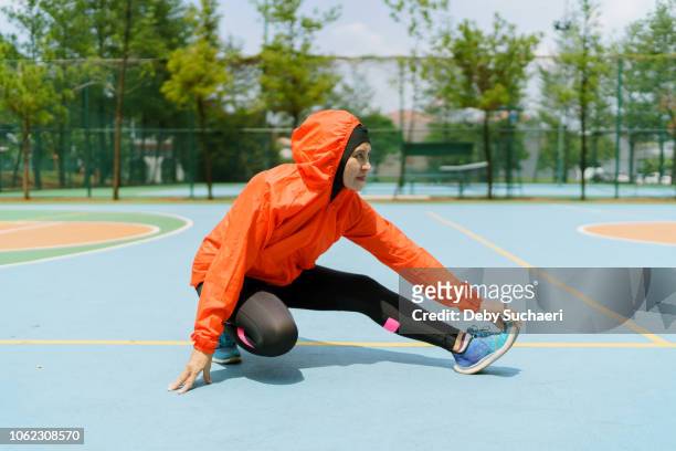 sporty muslim woman and runner with hijab stretching legs in the park - showus stock pictures, royalty-free photos & images