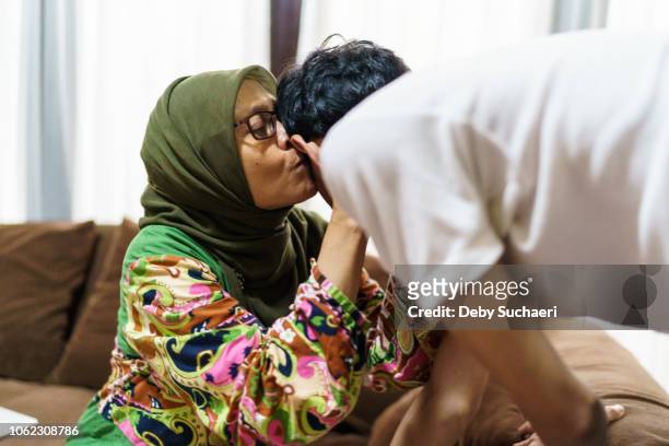 muslim woman with hijab hug and kiss her son