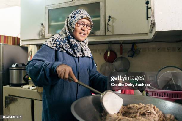 muslim woman with hijab cooking at the kitchen - malay archipelago stock pictures, royalty-free photos & images