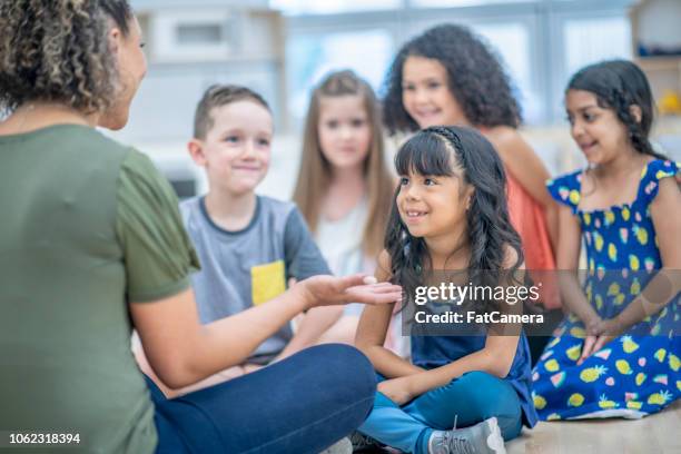 lehrer im gespräch mit ihrer klasse - small child sitting on floor stock-fotos und bilder