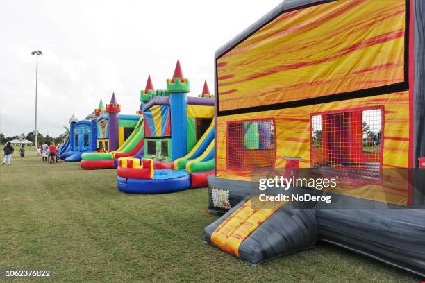 bounce houses at a public park - bouncy castle stock pictures, royalty-free photos & images