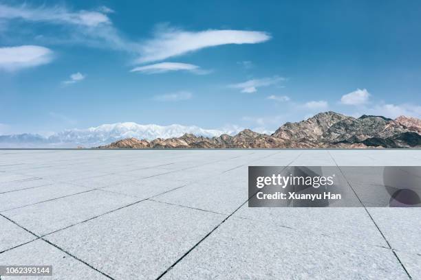 empty square with snow mountains - plateau stock-fotos und bilder