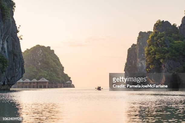 coppia che si gode il kayak mattutino, circondata da formazioni carsiche, vietnam del nord - vietnam foto e immagini stock