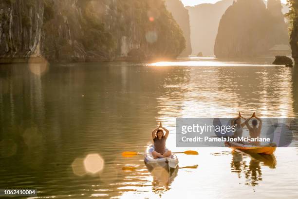 yoga e meditazione all'alba in kayak, baia di lan ha, vietnam - baia di ha long foto e immagini stock