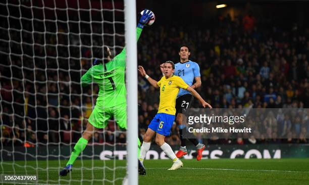 Brazil goalkeeper Alisson saves a shot from Edinson Cavani of Uruguay as Filipe Luis looks on during the International Friendly between Brazil and...