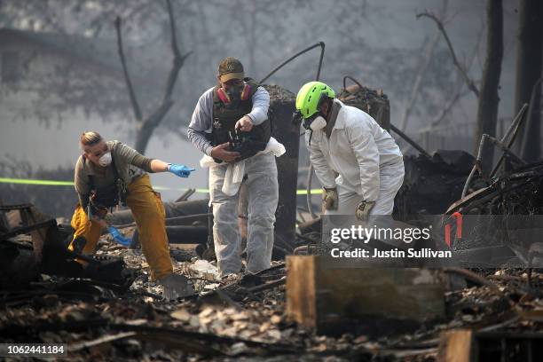 Rescue workers search an area where they discovered suspected human remians in a home destroyed by the Camp Fire on November 16, 2018 in Paradise,...
