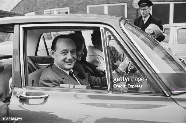 British speed record breaker Donald Campbell sitting in the driving seat of a car with his wife Tonia Bern and daughter Georgina, London, UK, 7th...