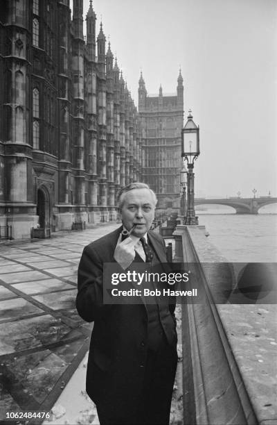 British Labour politician Harold Wilson smoking a pipe outside the Palace of Westminster, as he waits for the result of the Labour Party leadership...