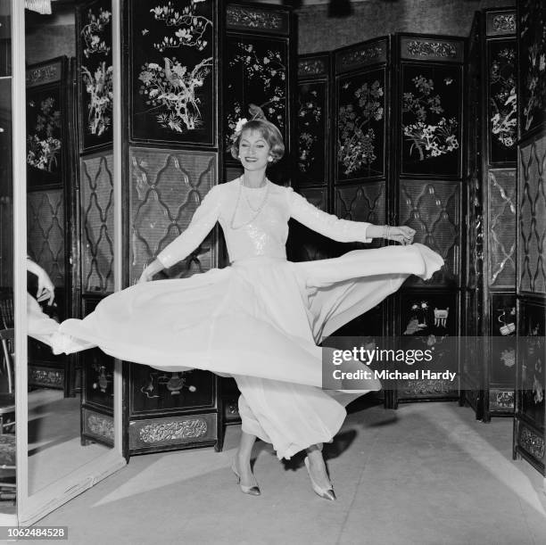 Fashion model wearing a long-sleeved evening dress by Chanel, Paris, France, 29th January 1963.