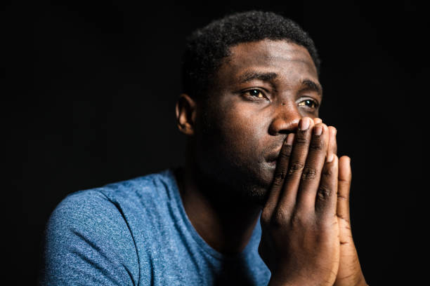 thoughtful man against black background - sad man black stock pictures, royalty-free photos & images