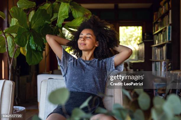 young woman spending a relaxing day in her beautiful home - respiração imagens e fotografias de stock