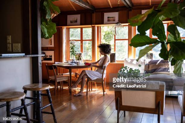 young woman spending a relaxing day in her beautiful home - african american woman barefoot stock pictures, royalty-free photos & images