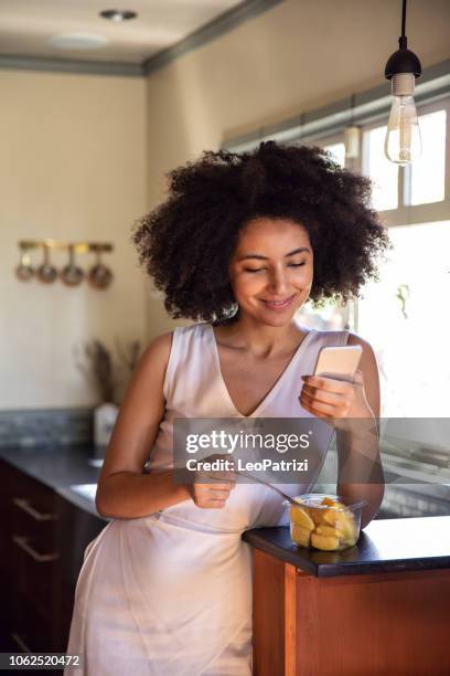 young woman spending a relaxing day in her beautiful home - multitasking stock pictures, royalty-free photos & images