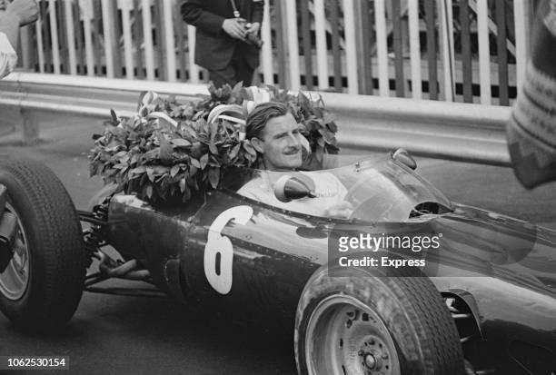 English racing driver Graham Hill pictured in the driver's seat of the Owen Racing Organisation BRM P57 BRM P56 1.5 V8 racing car after finishing in...