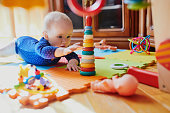 Baby girl playing with toys on the floor