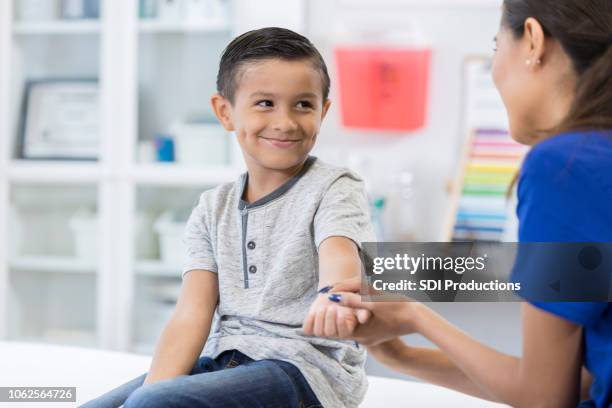 doctor examines boy's injured arm - broken trust stock pictures, royalty-free photos & images