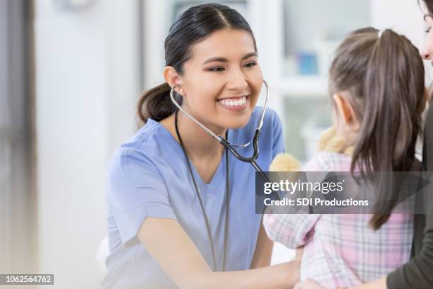 vertrouwen vrouwelijke arts onderzoekt jong meisje - cute nurses stockfoto's en -beelden