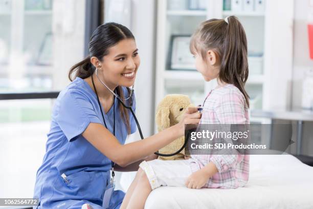 vertrouwen vrouwelijke kinderarts onderzoekt jong meisje - spoedeisende geneeskunde stockfoto's en -beelden