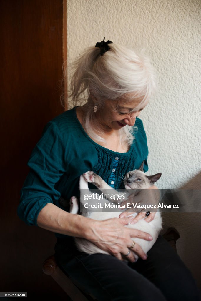 A mature woman plays with a kitten