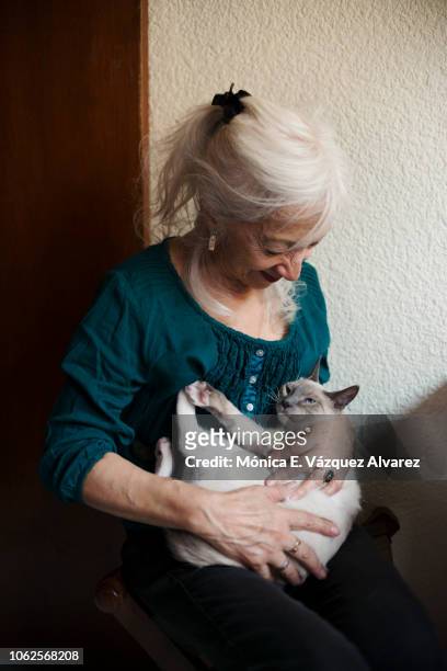 A mature woman plays with a kitten