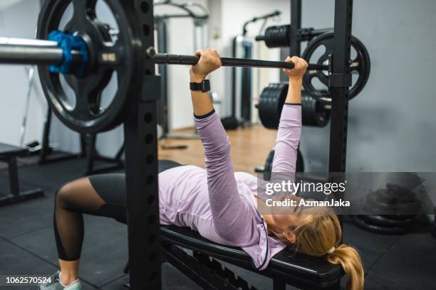 young woman exercising on the bench press - bench press stock pictures, royalty-free photos & images