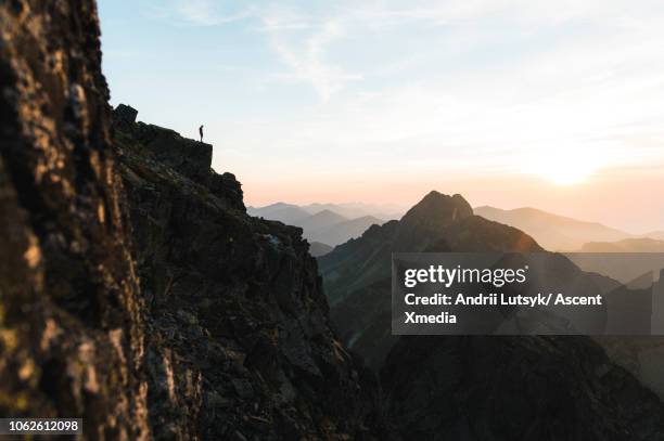 distant man stands on mountain ridge crest - tatra photos et images de collection