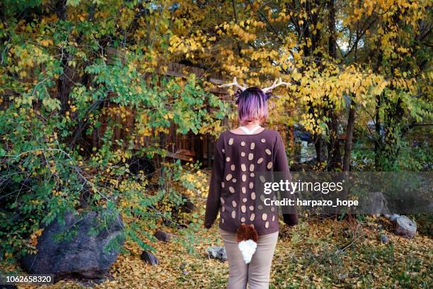 girl dressed in a deer costume surrounded by autumn leaves. - cute bums stockfoto's en -beelden