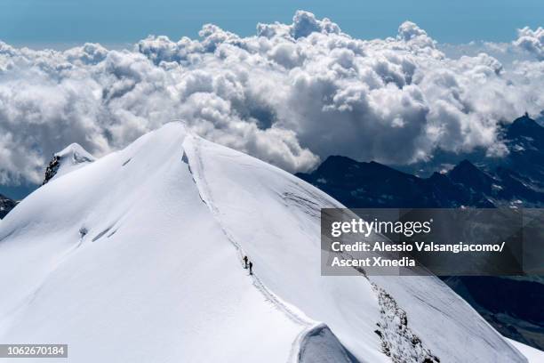 distant mountaineers follow narrow ridge crest - summit day 2 stock pictures, royalty-free photos & images