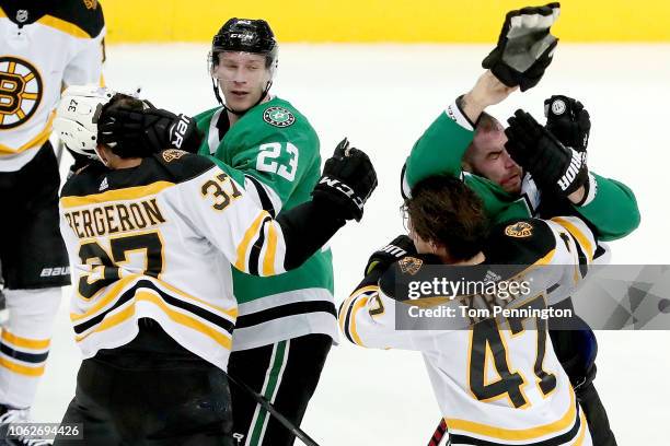 Patrice Bergeron of the Boston Bruins fight with Esa Lindell of the Dallas Stars as Torey Krug of the Boston Bruins fights with Roman Polak of the...