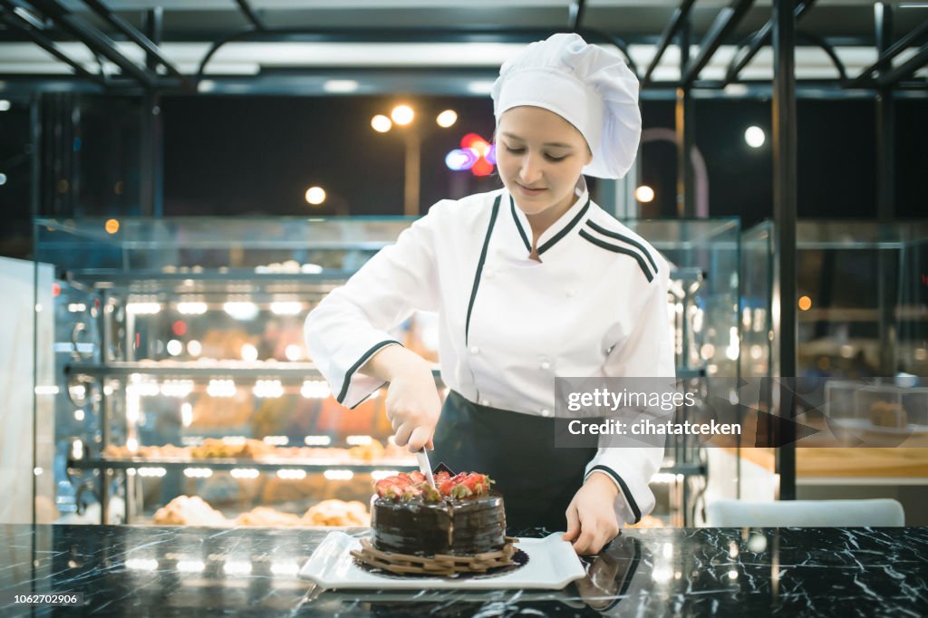 Chef woman cutting pastry