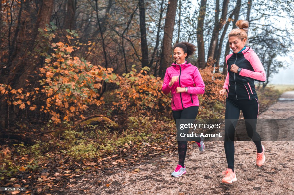 Jóvenes deportistas corriendo en la naturaleza en la mañana brumosa