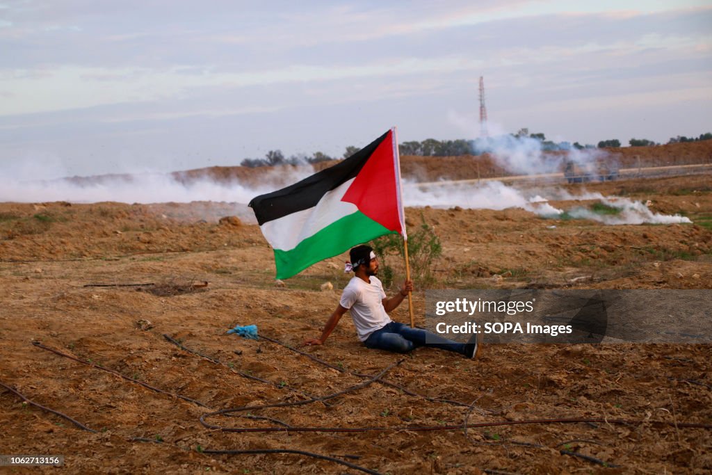 A Palestinian seen on the ground raising high a Palestinian...