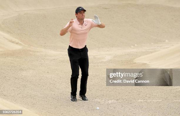Rory McIlroy of Northern Ireland leaps top get a line for his second shot from a deep fairway bunker on the par 4, third hole during the third round...