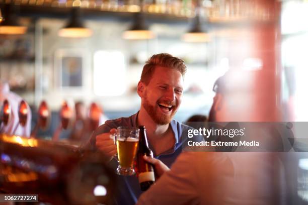 amigos tomando cerveza en barra de bar - beer bottle fotografías e imágenes de stock