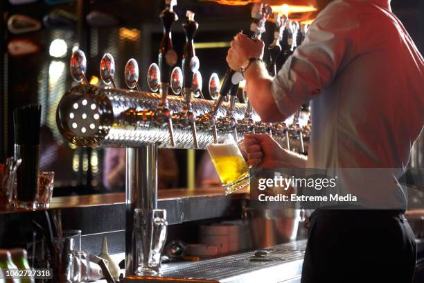 barista vierte cerveza en vaso - tirador fotografías e imágenes de stock