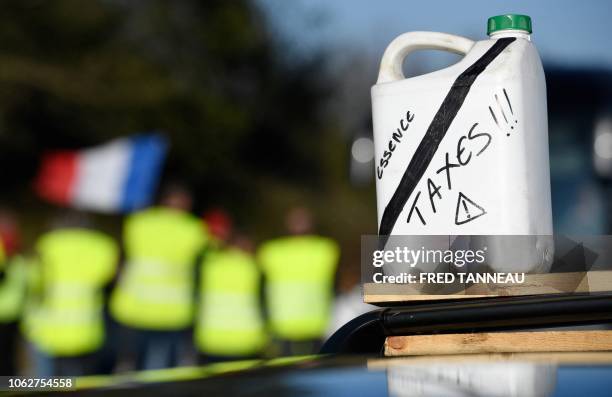 Jerrycan supposed to show the proportion of taxes in the fuel price is pictured during a road blockade action on November 17, 2018 in Chateaulin,...