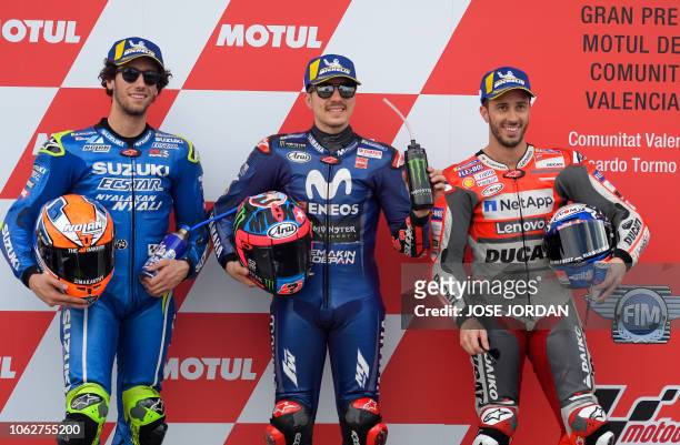 Movistar Yamaha MotoGP's Spanish rider Maverick Vinales celebrates earning pole position for tomorrow's race flanked by second placed Suzuki Ecstar...
