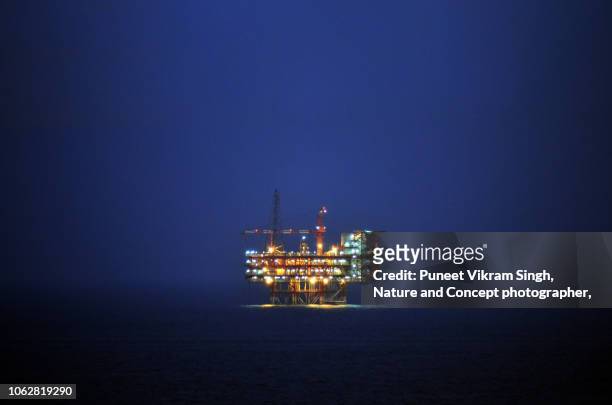 an offshore wellhead cum processing plant in the east coast kg basin during dusk - hydrocarbon stock pictures, royalty-free photos & images