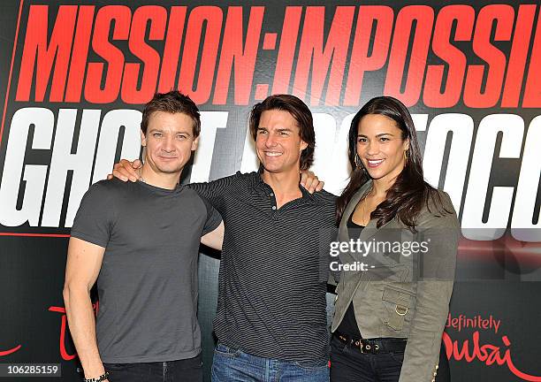 Actor Jeremy Renner, actor Tom Cruise and actress Paula Patton pose for a picture after holding a press conference about their upcoming film...